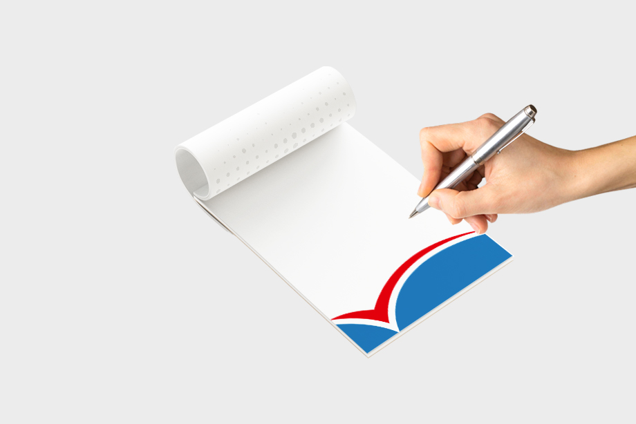 Hand schreibt auf individuell bedrucktem Notizblock