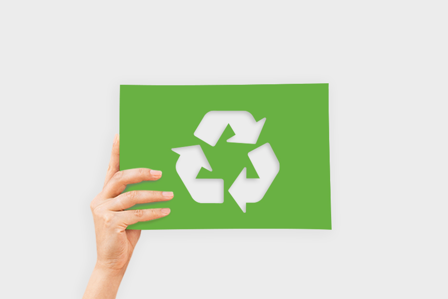 Hand hält ein grünes Blatt mit Recycling-Symbol – Umweltdruckprodukte und nachhaltige Drucklösungen